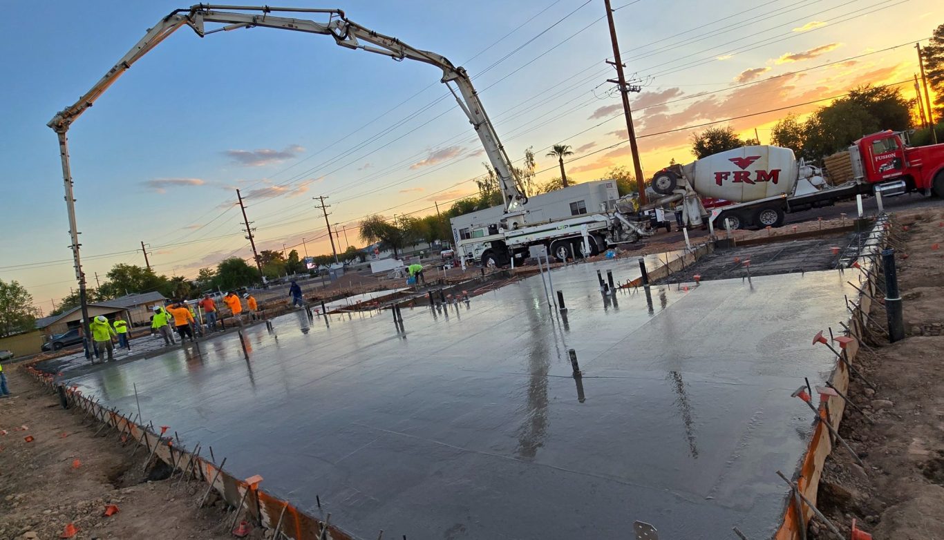 Boom pump with mixer pouring a foundation